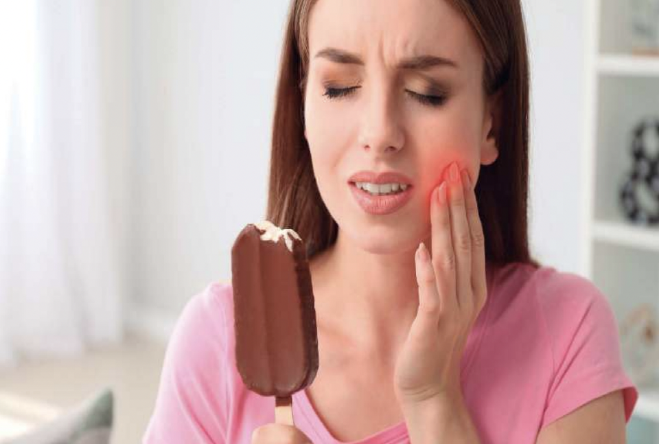 Chica comiendo helado que le afecta a sus dientes